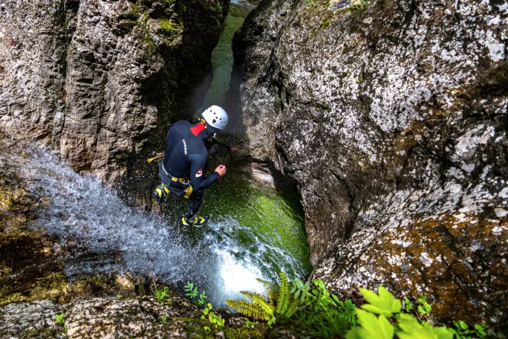 A person in wetsuit jumping into the Grmecica Canyon