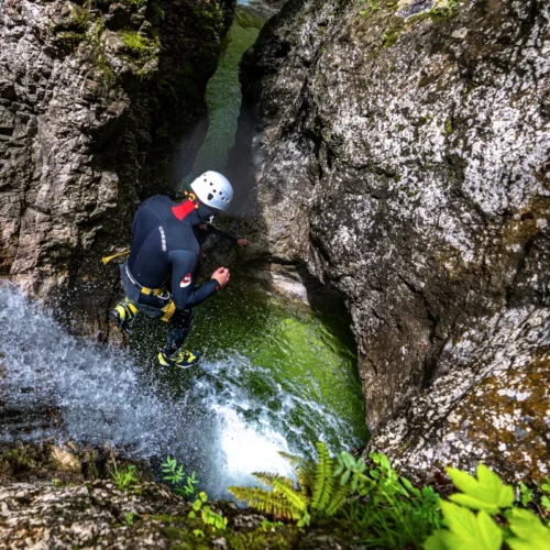 A person in wetsuit jumping into the Grmecica Canyon