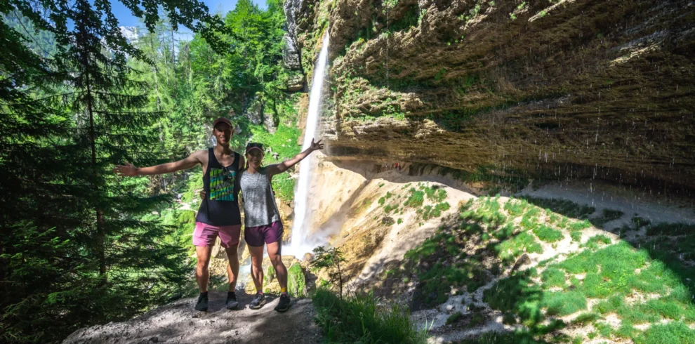 A couple standing in front of Pericnik Waterfall